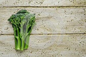Stems of broccolini on a wooden surface
