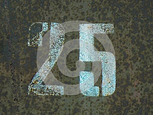 Stenciled numbers 25 on a brown rusty background