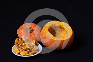 Step 2 Hollowing out pumpkin, removing seeds to prepare Jack`s lantern, isolated on black background, Step-by-step