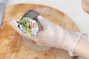 step 3. Cook& x27;s hands close-up. A chef makes sushi and rolls from rice, red fish, avocado and philadelphia cheese. step