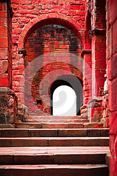 Step and arched doorways on red brick medieval ancient ruins