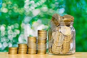 Step of coins stacks and gold coin money in the glass jar on tab