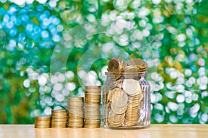 Step of coins stacks and gold coin money in the glass jar on tab