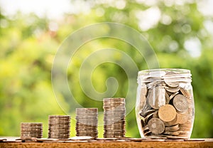 Step of coins stacks with tree growing on top, nature background, money, saving and investment or family planning concept, over su