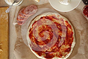 Step-by-step instructions for cooking pizza. Step 1. Roll the dough onto the dough and spread the tomato sauce. Dough with red