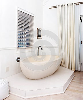 Step into modern luxury. Beautiful white bathtub in the corner of a stylish bathroom.