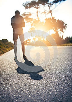 Step out of your shadow to find your strength. a young man looking defeated while out for a run.