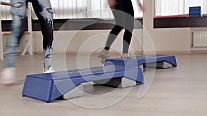 Step platforms. Girls in sports shoes doing exercises for aerobics. The concept of tightening in the gym for weight loss