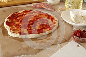 Step-by-step instructions for cooking pizza. Step 1. Roll the dough onto the dough and spread the tomato sauce. Dough with red