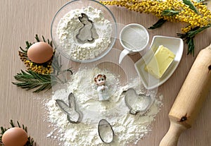 Step-by-step instructions for making Easter cookies. Ingredients for baking on a wooden light background. Rabbit molds, chicken