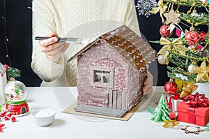 Step-by-step photo instructions for making a Christmas decor - a cardboard house, step 7 - applying PVA glue with a brush