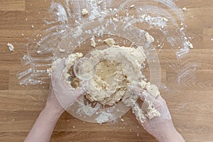 Step-by-step process of cooking dumplings. Top view. All ingredients are mixed, male hands knead the dough