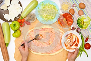 Step by step recipe for cooking homemade vegan pizza with zucchini, tomatoes, peppers, mozzarella . hands of a woman preparing a