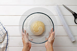 Step by step recipe galette or pie with nectarines. Female hands cover the dough with plastic wrap.