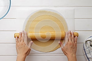 Step by step recipe galette or pie with nectarines. Female hands roll out the dough with a rolling pin.