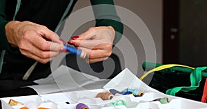 Step by step, woman`s dressmaker hand pulls the thread out of the box