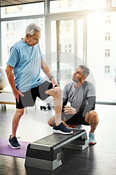 Step up and tell me how you feel. a young male physiotherapist assisting a senior patient in recovery.