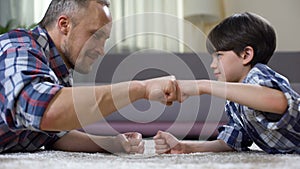 Stepfather and child fist bumping, partnership greeting, happy childhood moment