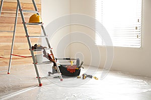 Stepladder and tools in room. Interior renovation