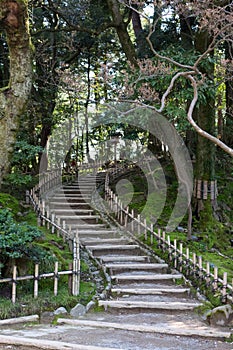 Stepped path with bamboo fence winding up hillside, at Kenrokuen gardens. Kanazawa, Japan