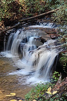 Stepped waterfall pouring into golden pond