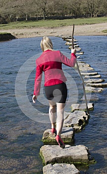 Stepping stones woman walking across river