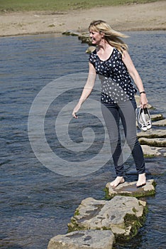 Stepping stones woman walking across river