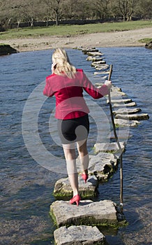 Stepping stones woman walking across river