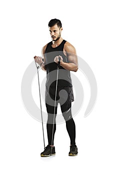 Stepping up his workout routine. Studio shot of a young man working out with a resistance band against a white