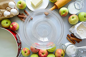 Steps of cooking apple pie. Fresh harvest apples, cinnamon, flour, sugar, butter, eggs, milk and baking mold