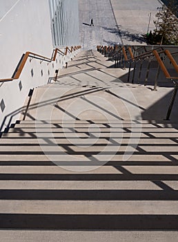 Steps down, crossed by shadows, on a sunny day at the Stavros Niarchos Cultural Center in Athens, Greece
