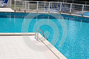 Steps ladder steel of corner in blue swimming pool