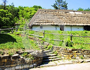 Steps up to the old clay house with a thatched roof