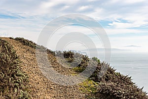 Stepway on top of the mountain with cloudy sky and ocean bay on the background