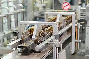 Sterile bottles on the production line conveyor of the pharmaceutical industry. Machine for iquid drugs glassware bottling.