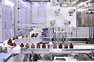 Sterile capsules for injection. Bottles on the bottling line of the pharmaceutical plant. Machine after checking sterile liquids.