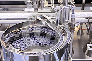 Sterile capsules for injection. Bottles on the bottling line of the pharmaceutical plant. Machine after checking sterile liquids.