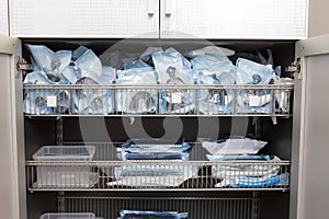 Sterile sealed dental instruments are stacked in a drawer