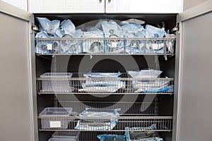 Sterile sealed dental instruments are stacked in a drawer