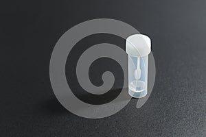 Sterile white plastic container or jar for stool or feces analysis or coprology test on a black background