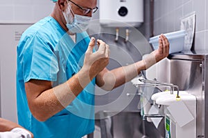 Sterility, cleanliness concept. male doctor washing hands after operation