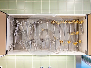 In  sterilization unit on a shelf, all these surgical instruments are hanging