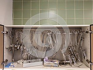 In  sterilization unit on a shelf, all these surgical instruments are hanging