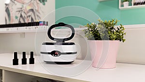 a sterilizer for manicure tools is on the table by the mirror