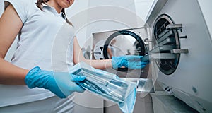 Sterilizing medical instruments in autoclave. Dental office photo