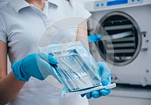 Sterilizing medical instruments in autoclave. Dental office photo