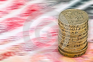 Sterling pound depreciation devaluation reduction value concept closeup macro view at UK currency stack of one pound coins