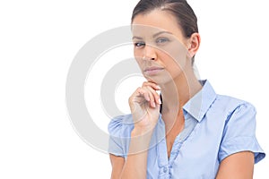 Stern businesswoman with hand on chin
