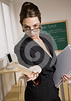 Stern businesswoman holding ruler and notebook