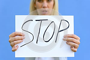 Stern young woman holding up a stop sign